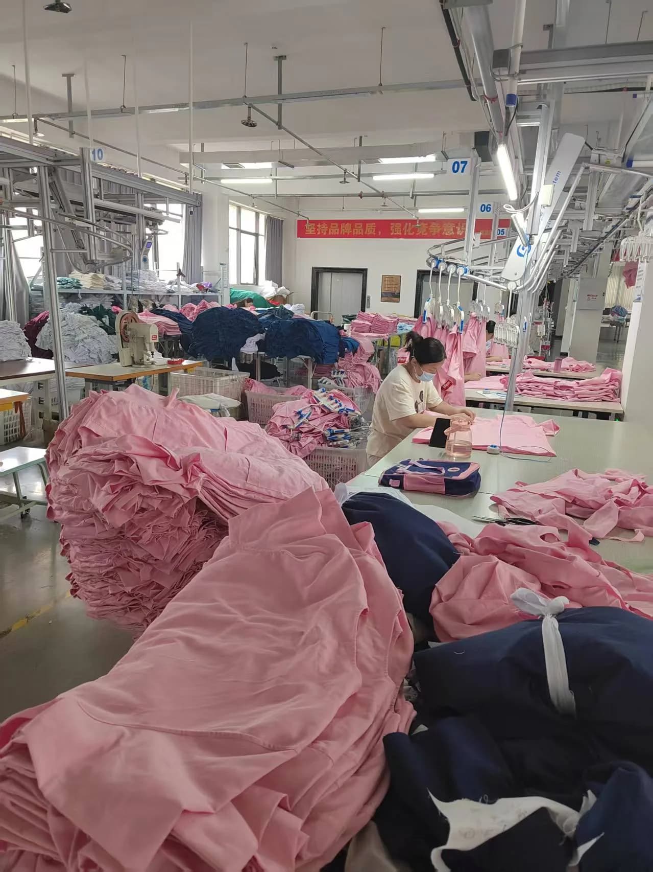 Operator arranging a pink garment on a finishing table